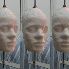 Photo of a face with a laser being project on it